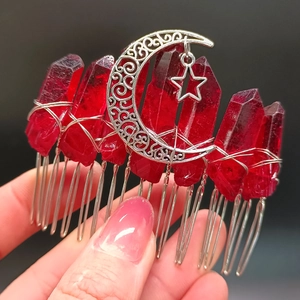Detailaufnahme von Haarkamm für Braut mit Mond-Stern-Anhängern und roten Kristallen