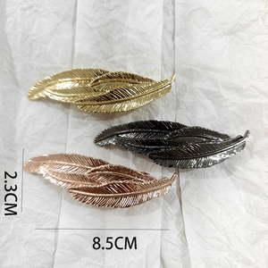 Detailed view of leaf shaped metal hair clips in gold, gun black and rose gold finishes