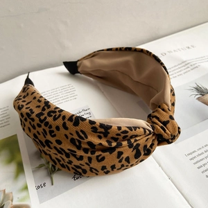 Detail of leopard print knot headband with a stylish crossover design on fabric