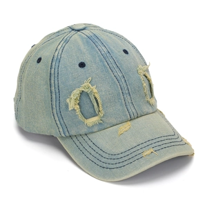 Detail of light blue distressed denim baseball cap with vintage frayed holes and stitched brim