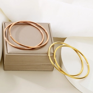 Minimalist stackable bangle set in polished gold and rose gold on a premium display