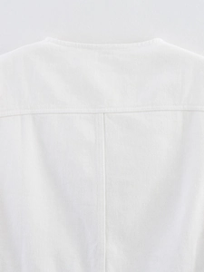 Detailed close-up of white denim vest showing precise stitching and rivet button texture
