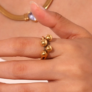Detail of 18K gold plated ring with polished spherical clusters worn by a model