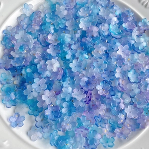 Macro detail of blue and purple gradient flower resin beads with gold glitter texture