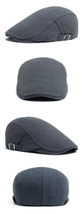 Detail view of dark grey herringbone newsboy cap with adjustable metal side buckle
