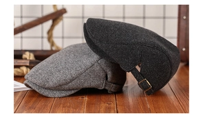 Close-up of wool texture and metal adjustable buckle on grey newsboy caps