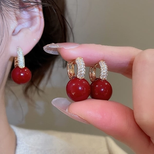 Close-up of red zircon resin hoop earrings with gold-plated finish and elegant detailing