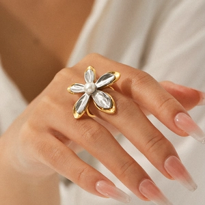 Two-tone stainless steel flower ring with white pearl on model's finger