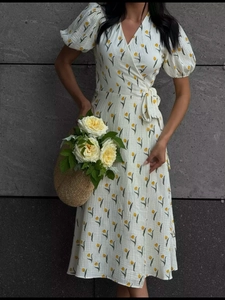 Detailed view of puff sleeves and yellow floral patterns on a wrap cotton dress