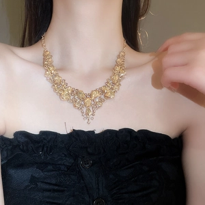 Close-up of a vintage V-shaped gold necklace with sparkling yellow crystal pendants