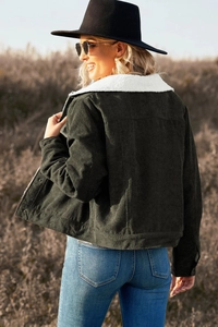 Detail of dark green corduroy jacket with white shearling collar for winter comfort