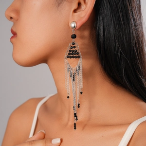 Long silver chain tassel earrings with black geometric glass beads on model