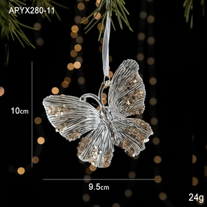 Detail of butterfly Christmas ornament with champagne gold glitter on pine branch