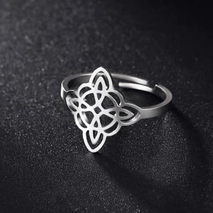 Macro detail of silver stainless steel witch's knot ring with adjustable open band design