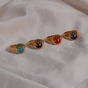 Detail of four 18K gold plated stainless steel rings with colorful enamel flame patterns