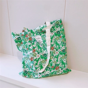 Detailed close-up of green floral cotton tote bag with soft fabric and woven handles