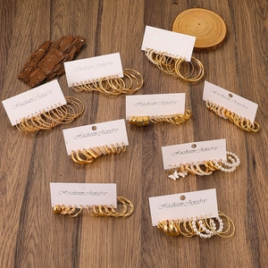 Detail of gold earring set with pearls and rhinestones on white display card