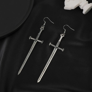 Gothic retro silver sword earrings with vintage metal texture on black silk background