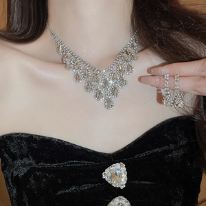 Silver teardrop rhinestone necklace and earrings set worn by a model in a luxury style