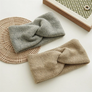 Close-up of knit cross knot headbands in grey and beige showing soft wool texture
