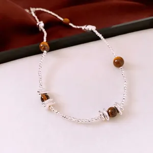 Collier vintage en perles d'oeil de tigre et perles argentées sur fond de velours