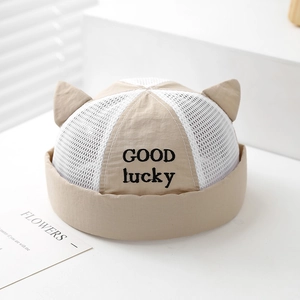 Detailed macro view of beige mesh cat ear hat with GOOD lucky embroidery and breathable fabric