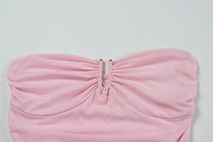 Detail eines rosa trägerlosen Abendkleides mit Raffungen und goldenen Zierperlen