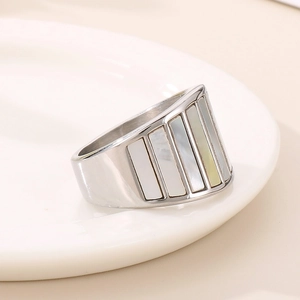 Macro shot of silver wide-band steel ring with five inlaid rectangular white shells