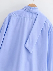 Detail view of light blue shirt back collar with ribbon tie and precise stitching