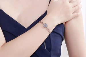 Detailed close-up of a silver elephant pendant bracelet with paperclip chain on wrist
