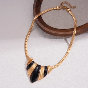 Detail of gold geometric enamel pendant with stylish flat snake chain and lobster clasp