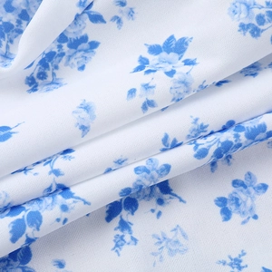 Dettaglio macro del tessuto bianco con eleganti stampe floreali blu e trama fine