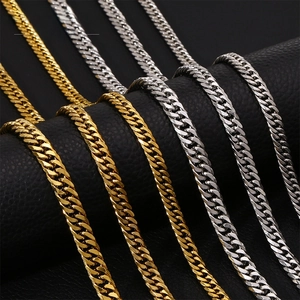 Detailed close-up of gold and silver cuban curb chains on black leather display