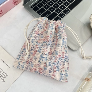 Close-up of corduroy drawstring pouch with floral patterns for travel storage