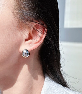 Polished silver water drop stud earring worn on earlobe for a minimalist elegant look