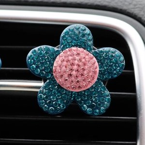 Detail of pink and blue rhinestone flower car vent clip mounted on air outlet grille