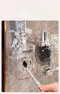 Detail of wall-mounted toothpaste dispenser with glacier texture and silver rabbit decor