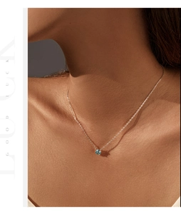Nahaufnahme einer S925 Silberkette mit rosenförmigem blauem Kristallanhänger am Hals