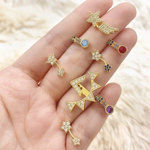 Macro shot of gold star tassel earrings with colorful zircons held in a palm
