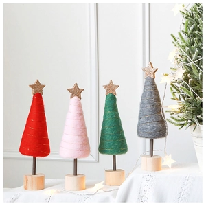 Detailed view of handmade pink wool felt Christmas trees with golden stars and wooden bases