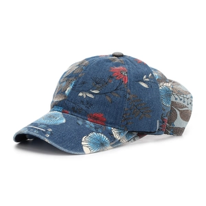 Close-up of dark blue denim baseball cap with elegant red and white floral patterns