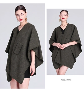 Detail of dark green knit poncho cardigan featuring a large pocket and draped silhouette