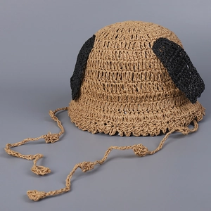 Detail showing hand-woven straw texture and cute dog ear decor on children sun hat