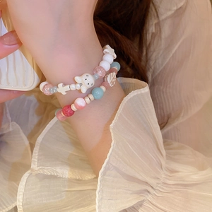 Detail of double-layer beaded bracelet with opal charms and cute cartoon rabbit