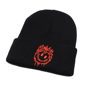 Close-up of black knit beanie featuring red embroidered flaming smiley face and text