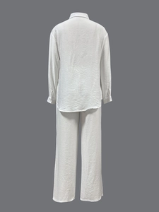 Detail of white long sleeve linen set showing back view of loose shirt and wide trousers