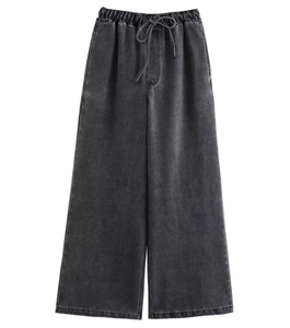 Detail einer weiten, gewaschenen Denim-Hose in Anthrazit mit elastischem Kordelzugbund