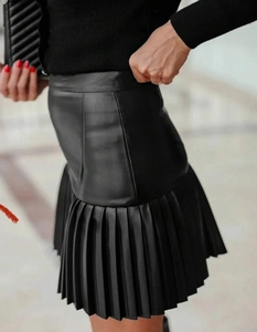 Detailaufnahme des Faltenbeutels und der Ledertextur an diesem schwarzen Minirock mit hoher Taille