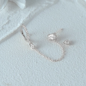 Detail of 925 sterling silver geometric heart earrings with sparkling zircon tassels