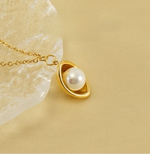 Detail showing an 18k gold plated ingot pendant necklace with a white pearl inlay
